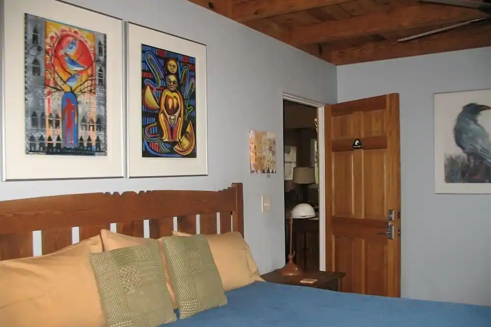 a bedroom with a bed and two paintings on the wall