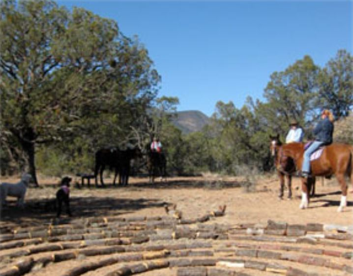 a group of people are riding horses through a wooden labyrinth .