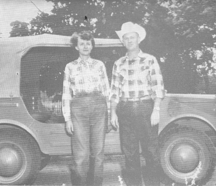 A man and a woman standing in front of a jeep