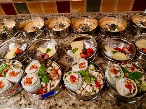 A bunch of containers filled with different types of food on a counter.