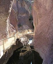 A bridge leading to a cave in the middle of a canyon.