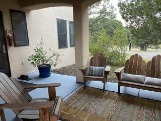 A porch with two wooden chairs and a bench