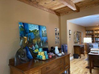A living room with a dresser and a painting on the wall