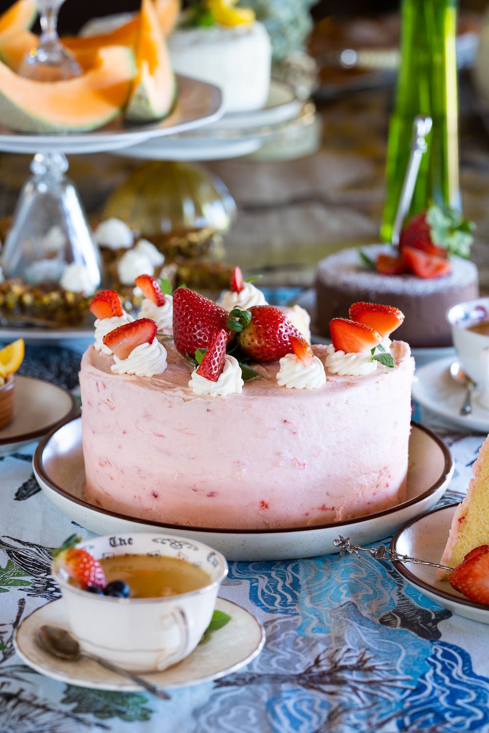 A cake with strawberries on top of it is on a plate on a table.