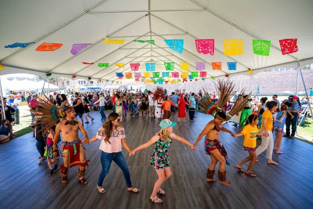 A group of people are dancing under a tent.