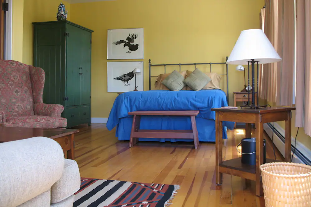 a bedroom with yellow walls and a blue bed