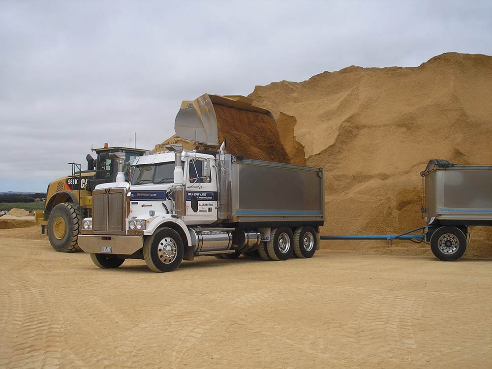 digger dumping dirt into truck