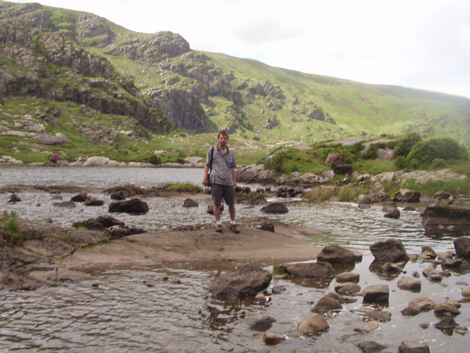 A man standing on a rock in the middle of a river