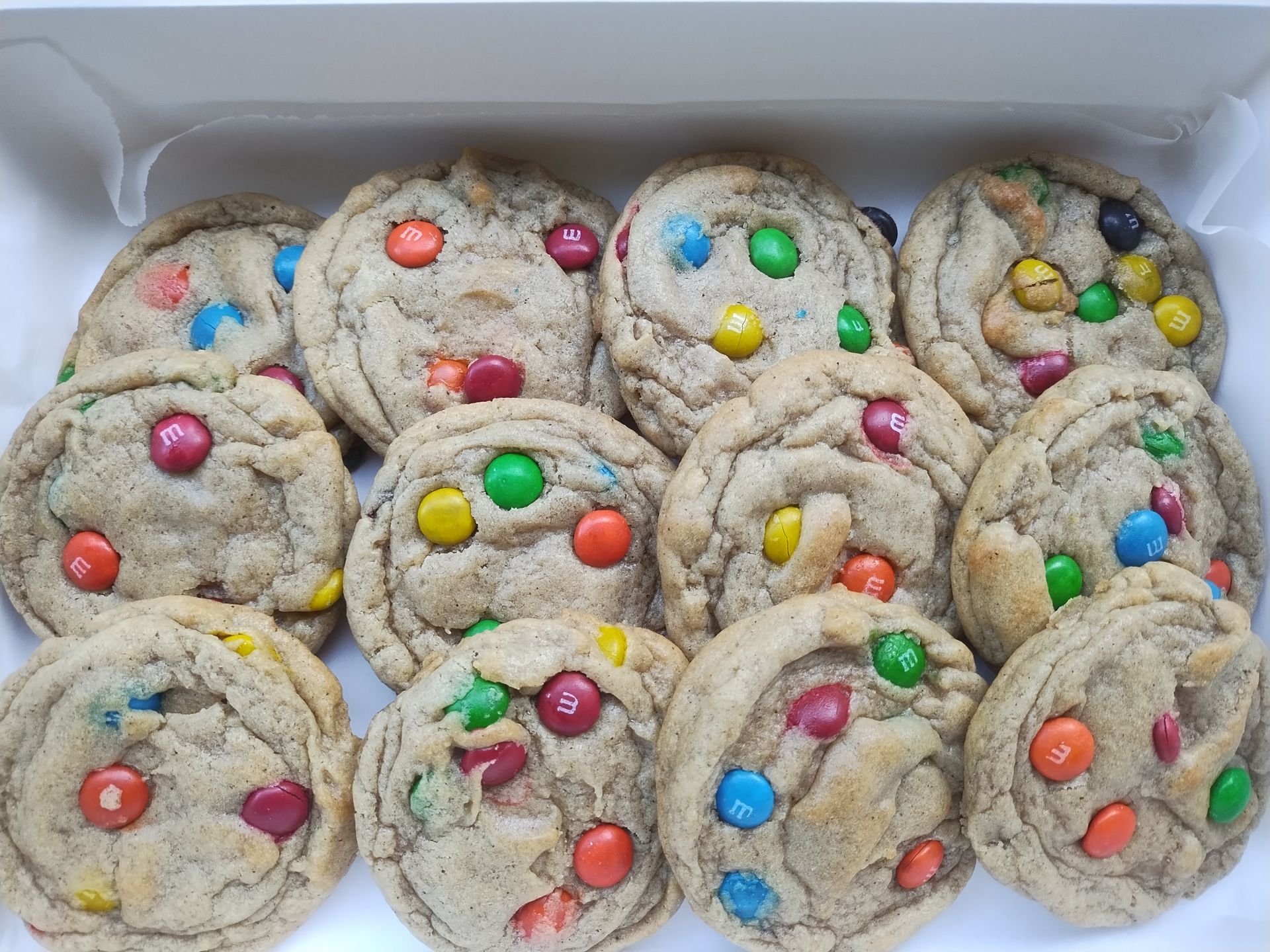 Box of thick, round cookies studded with M&Ms.