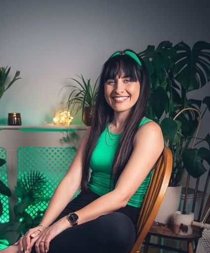 A woman in a green tank top is sitting in a chair