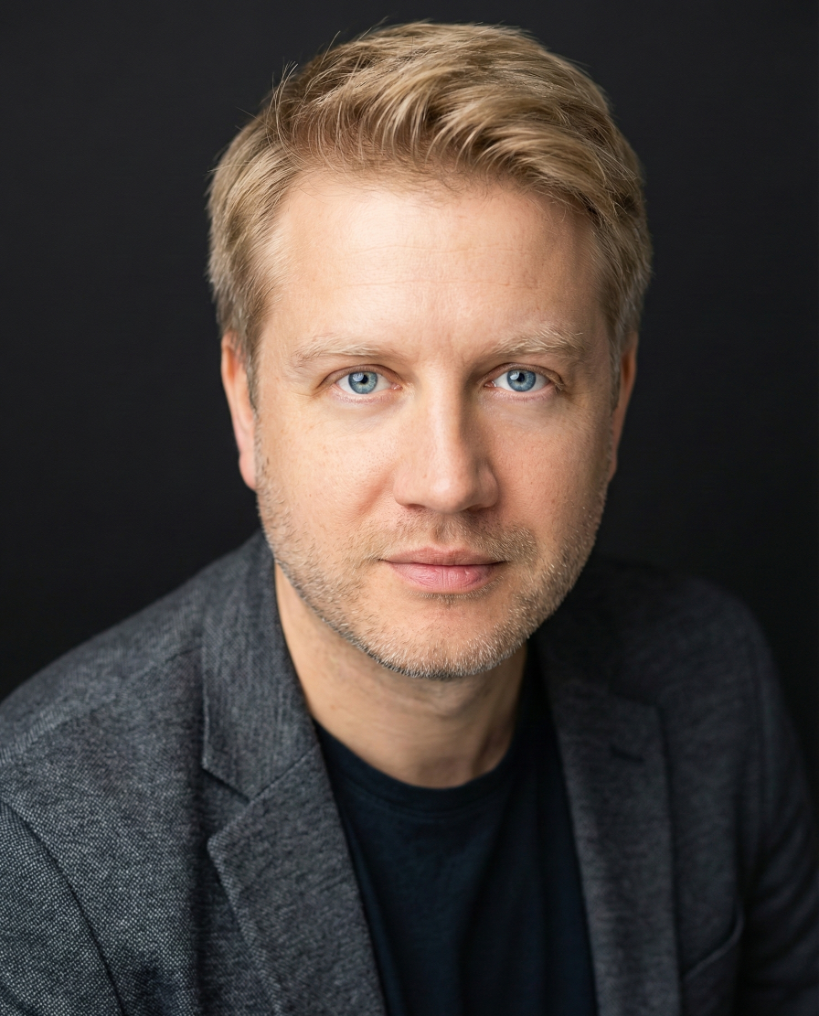 A man with a beard is wearing a suit and tie. Nelis Parts Kyro CFO fractional CFO services