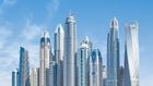 A city skyline with a lot of tall buildings against a blue sky