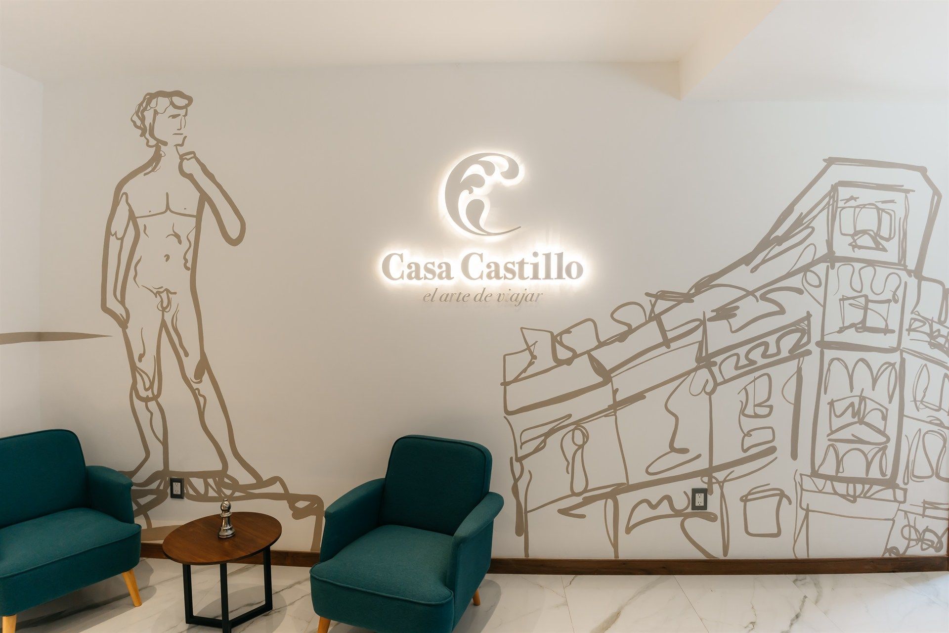 Una habitación con sillas y una mesa con un dibujo de un hombre en la pared.