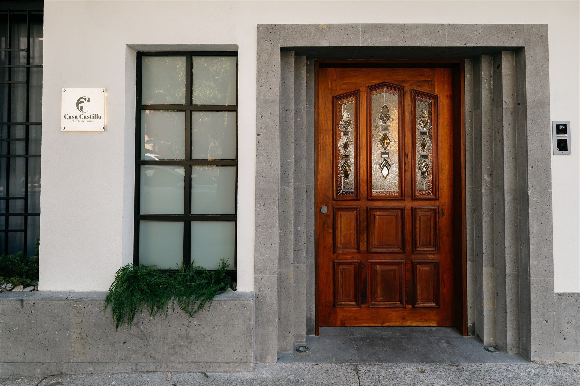 A white building with a wooden door and a window