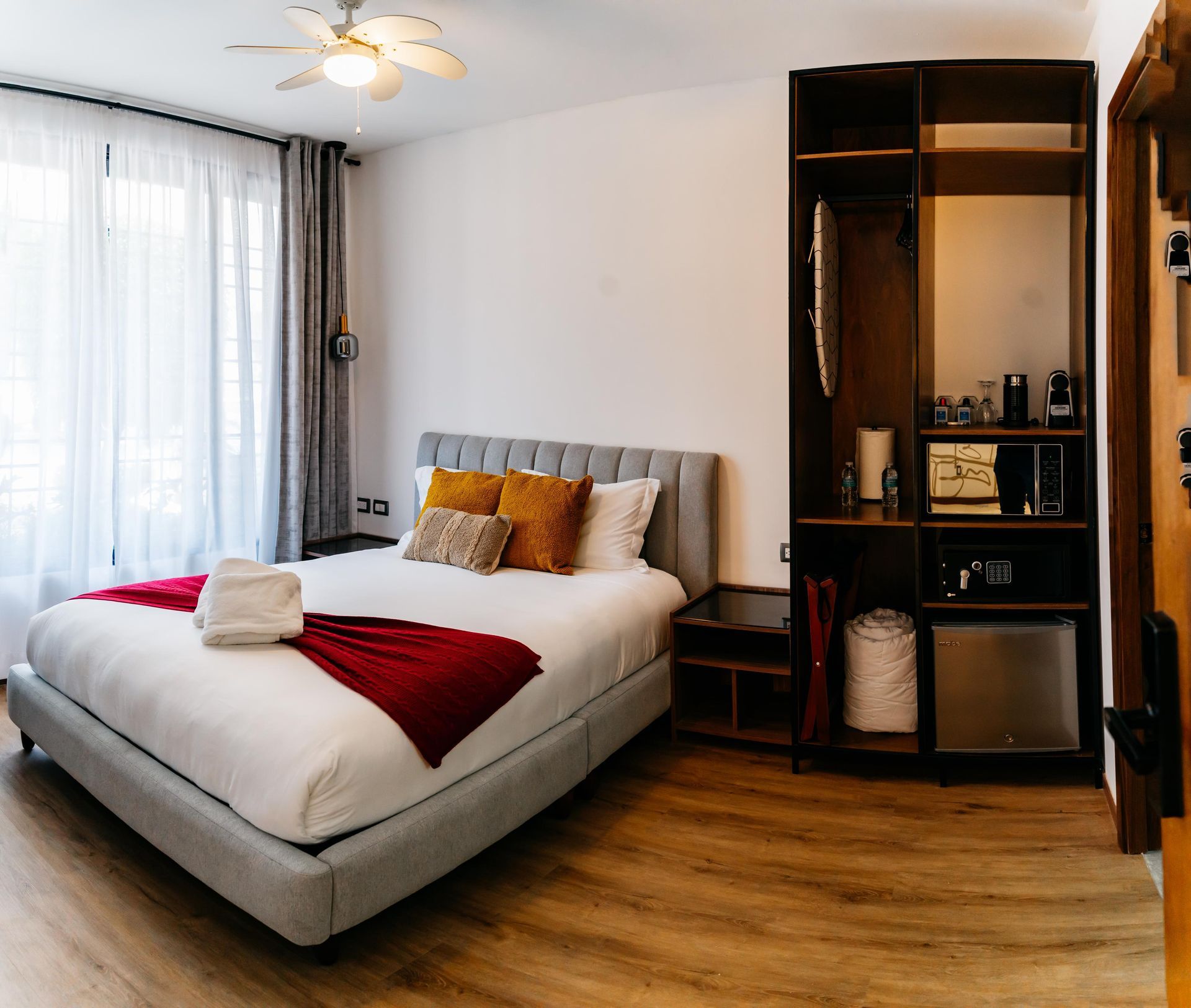 Una habitación de hotel con una cama grande y un ventilador de techo.
