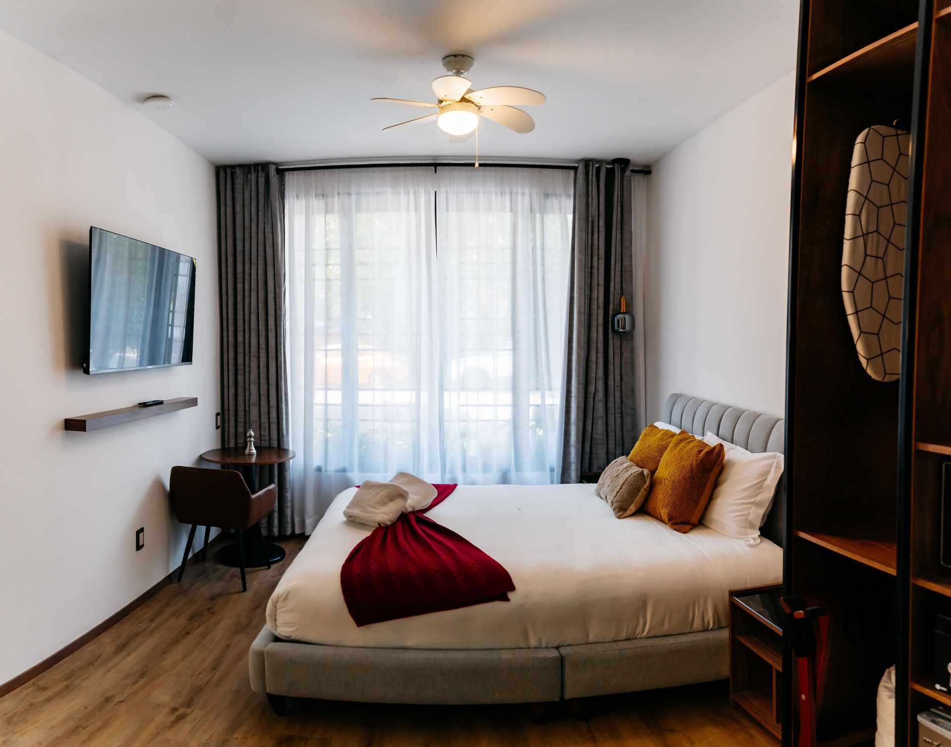 Un dormitorio con una cama grande y un televisor de pantalla plana en la pared.