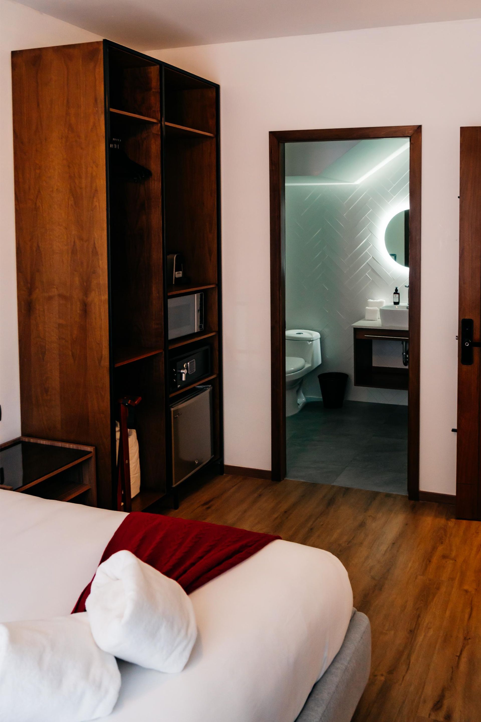 Una habitación de hotel con una cama y una puerta que conduce a un baño.