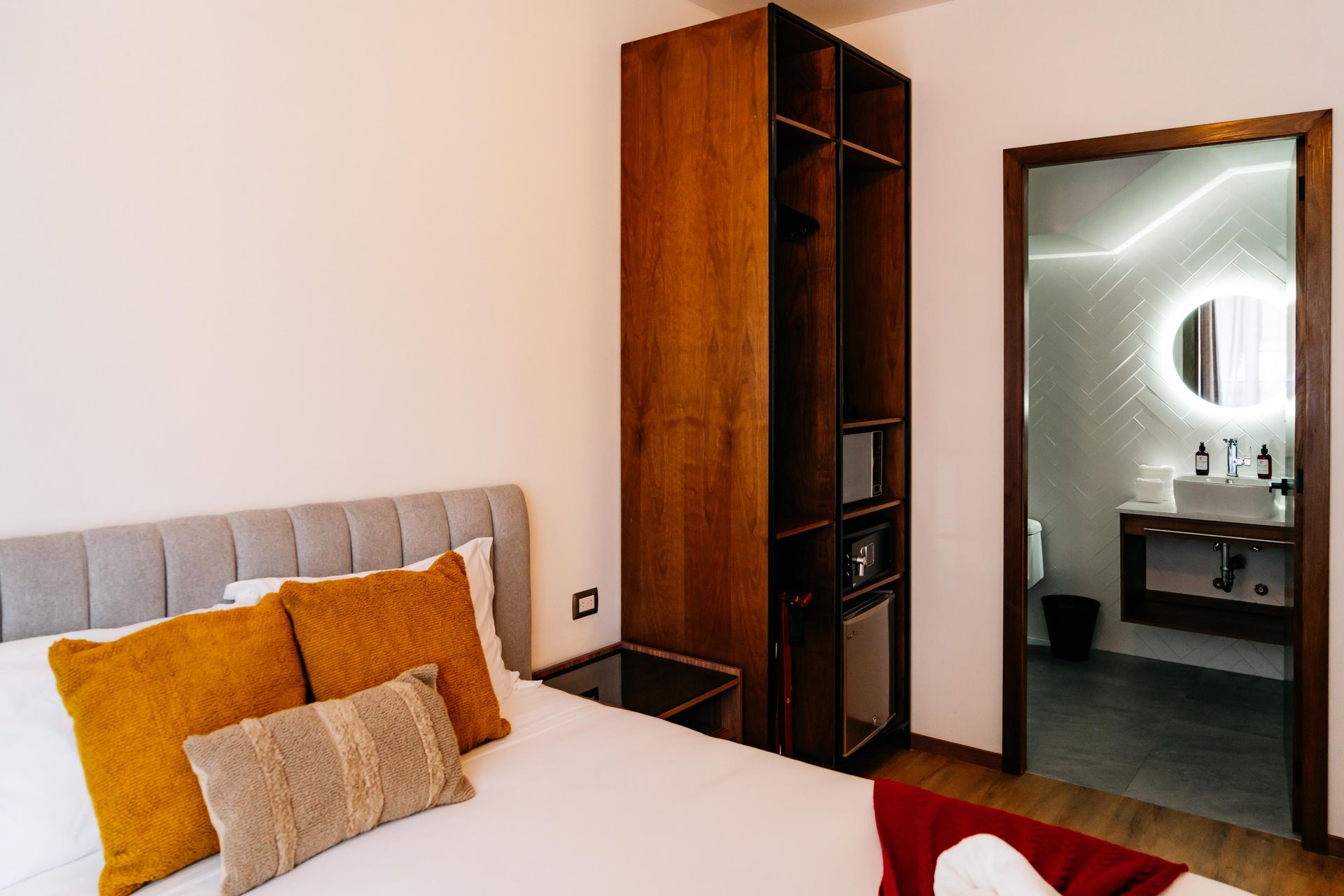 Un dormitorio con cama, mesita de noche, armario y baño.