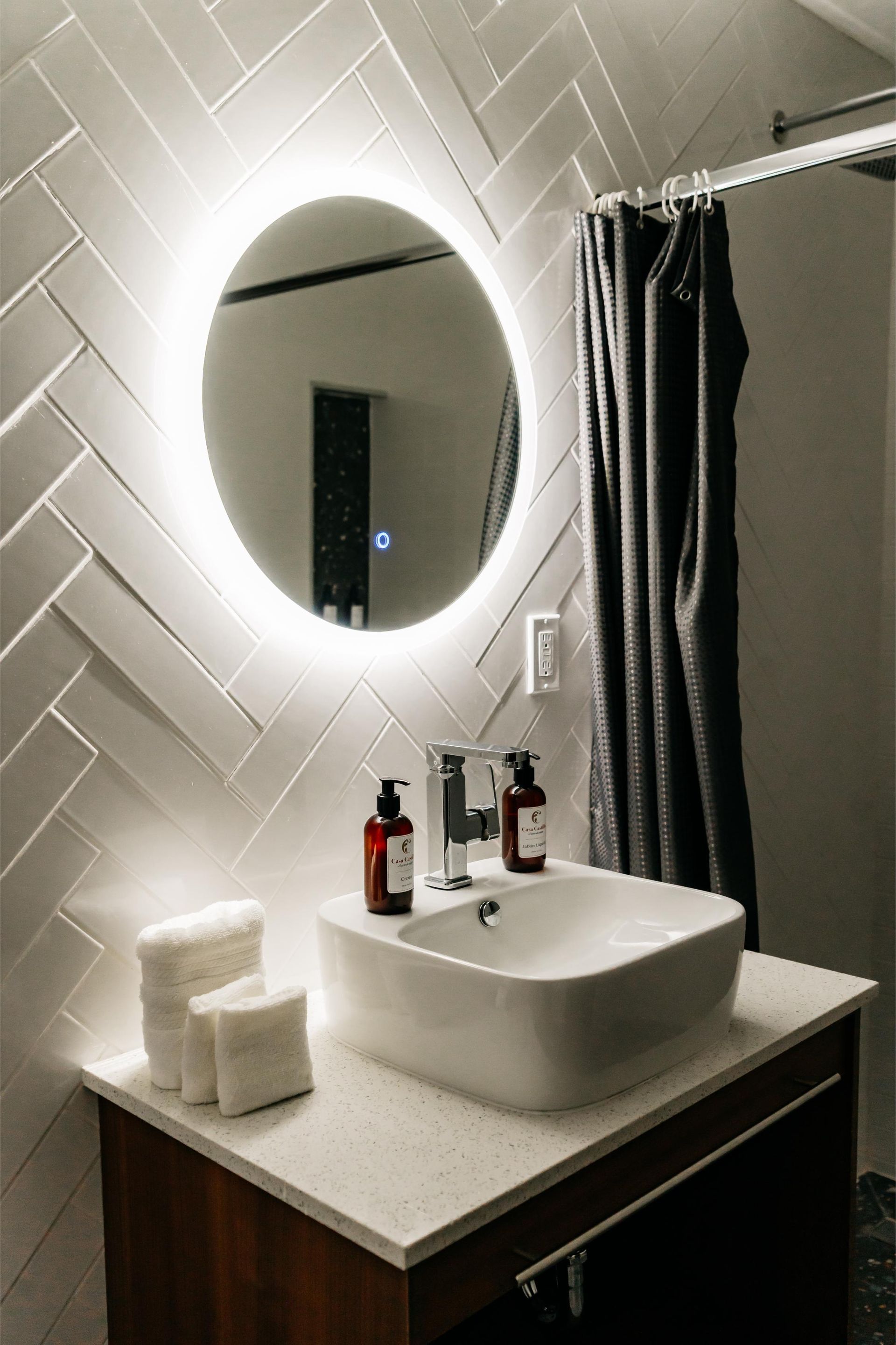 Un baño con lavabo, espejo y cortina de ducha.