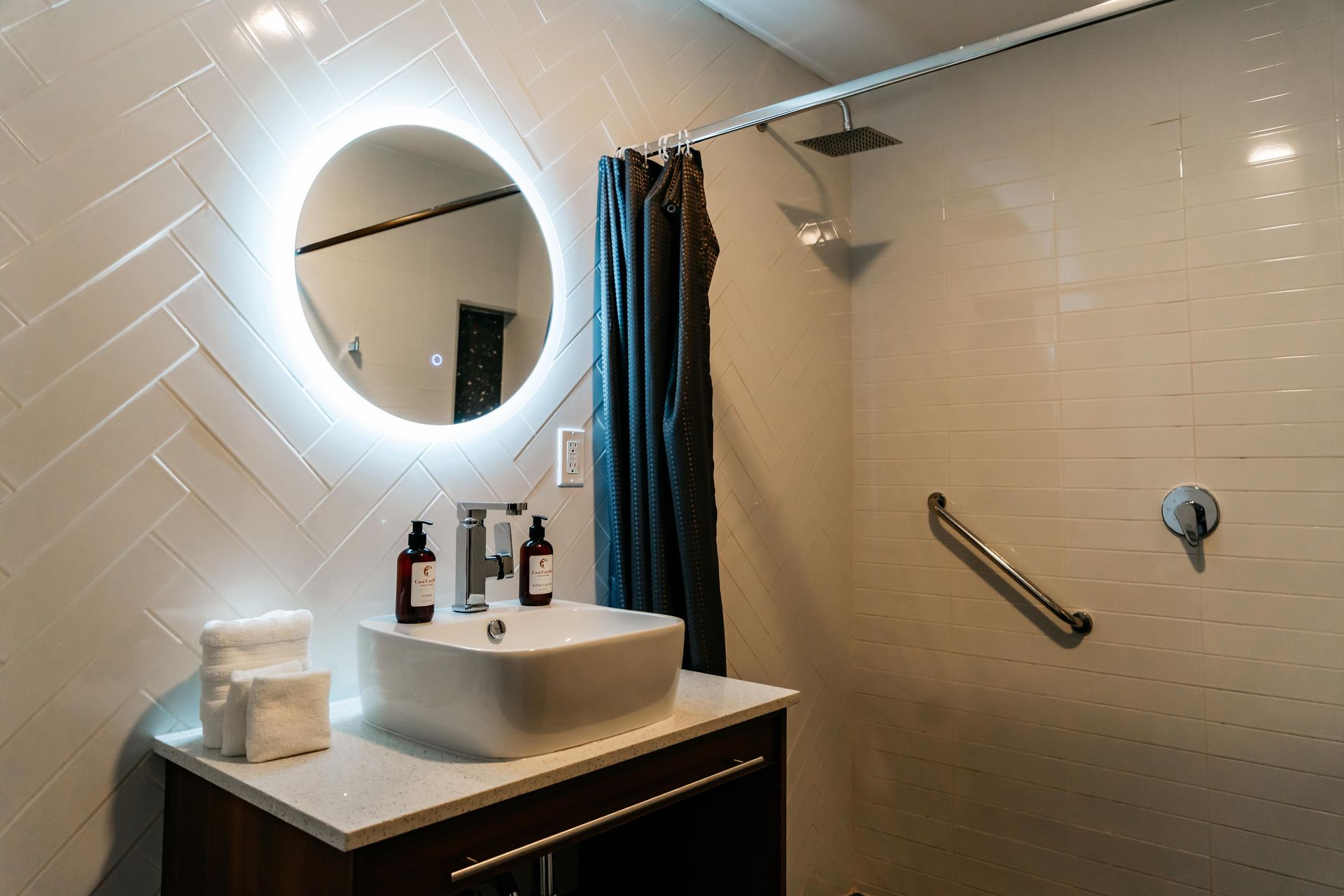 Un baño con lavabo, espejo y ducha.