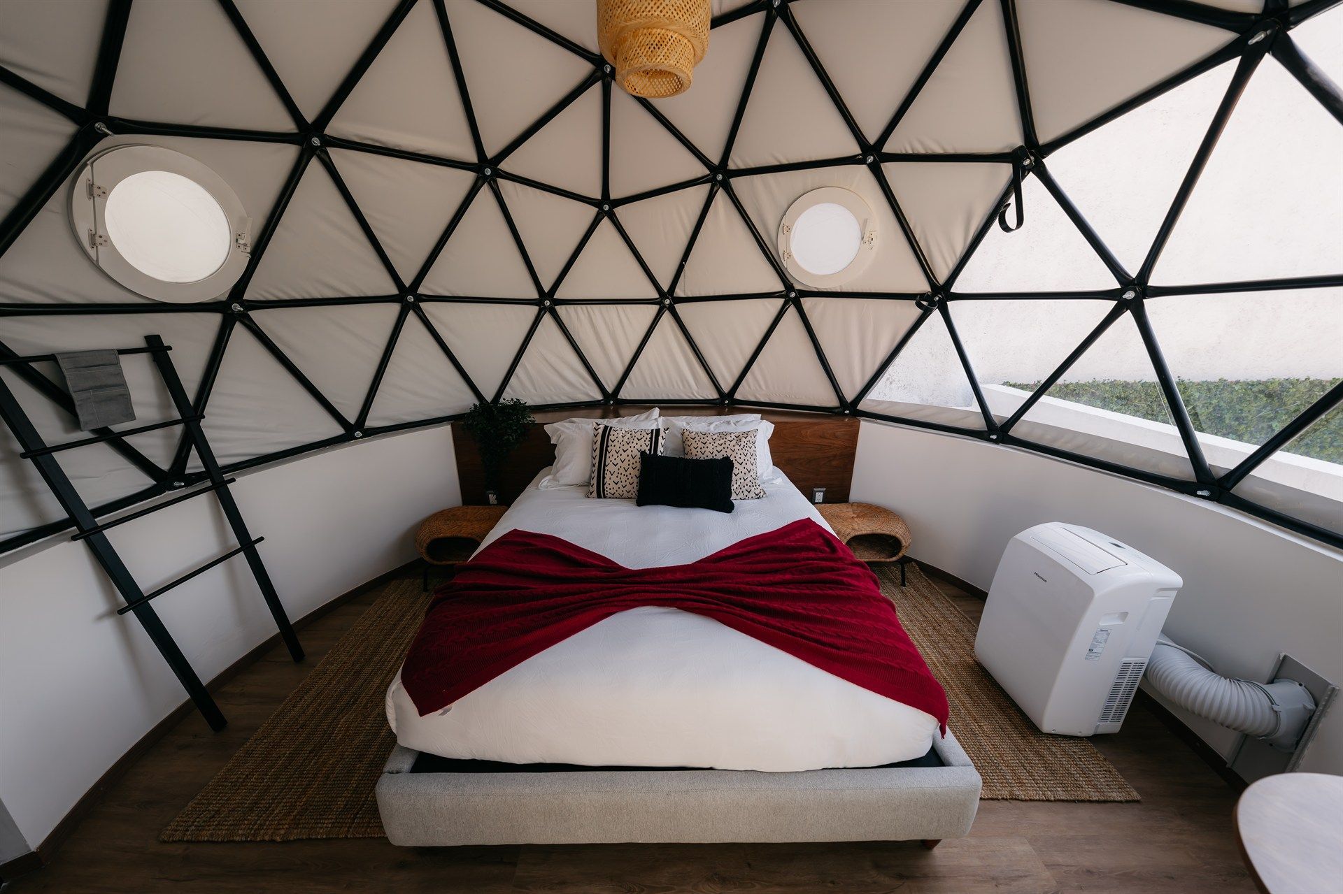 Un dormitorio en forma de cúpula con una cama y una escalera.