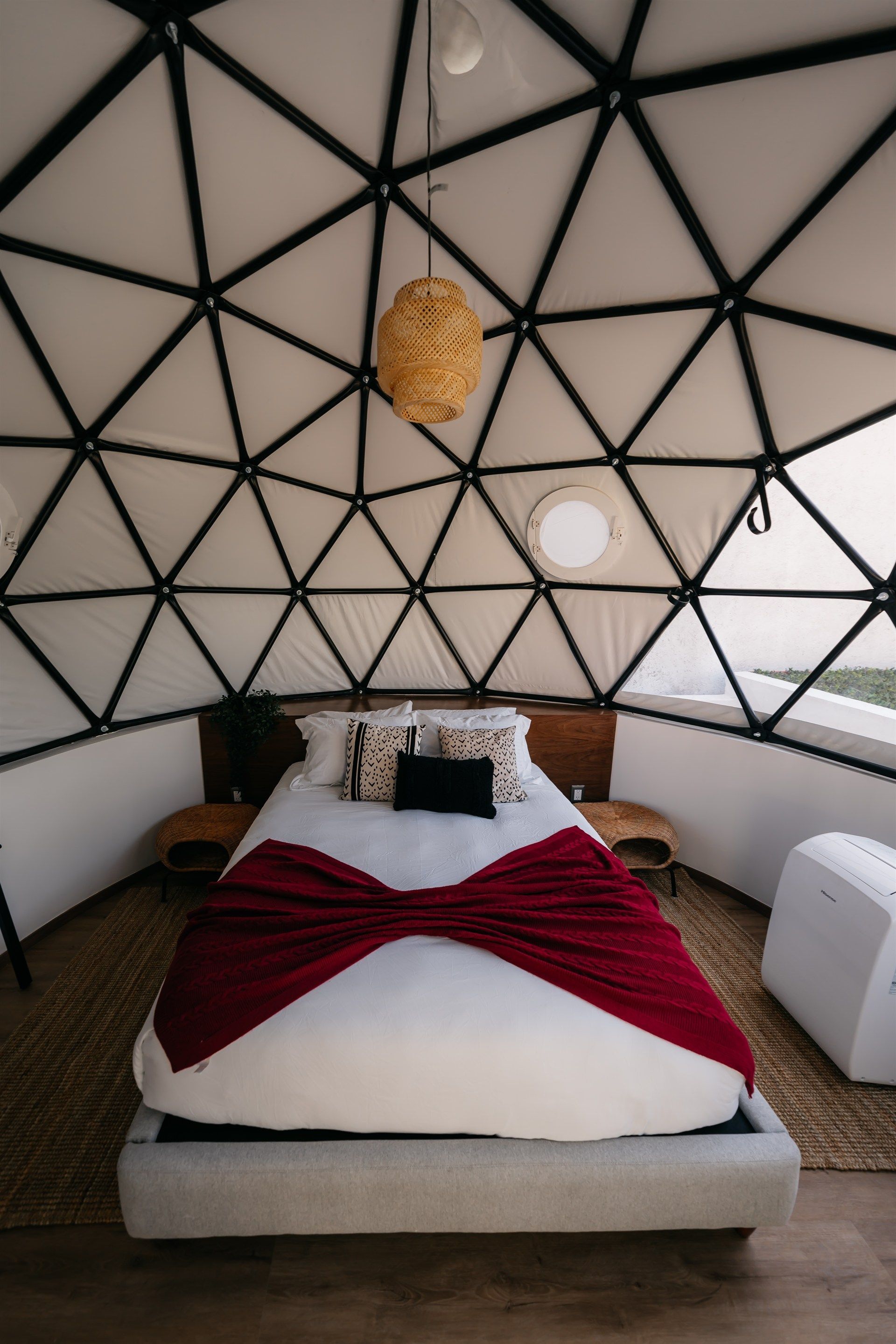 Una cama en forma de cúpula con una manta roja encima.
