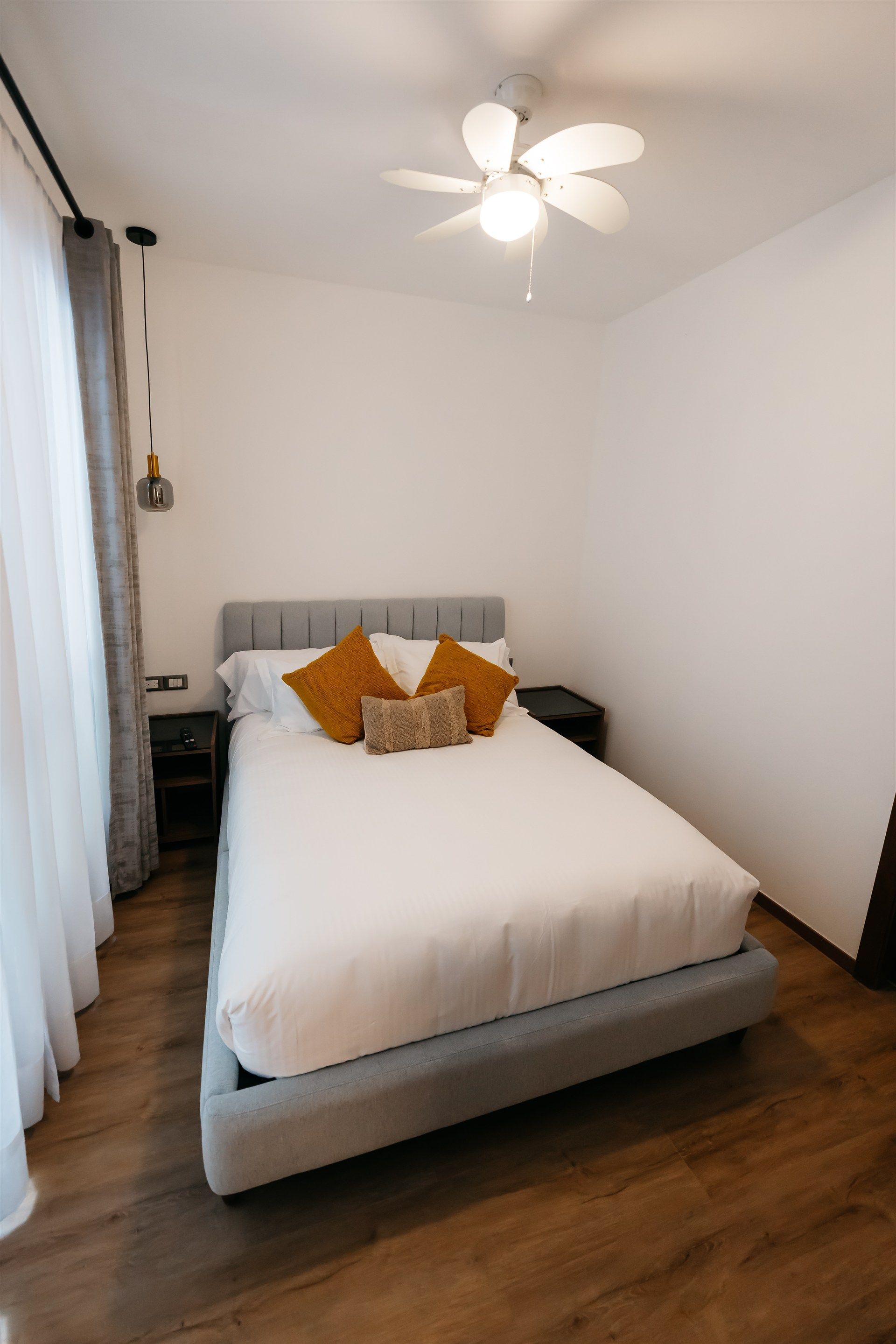 Un dormitorio con una cama y un ventilador de techo.