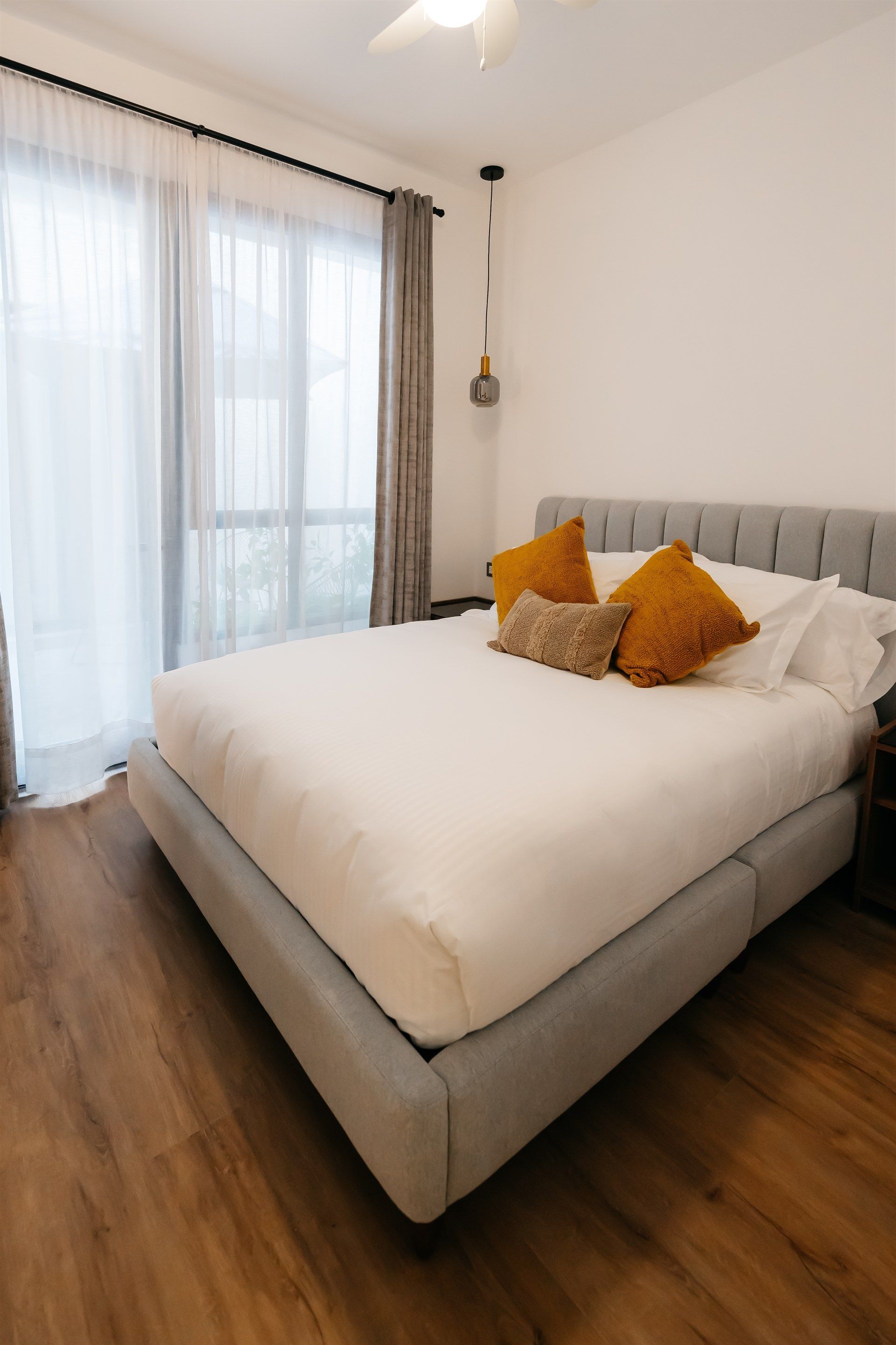 Un dormitorio con una cama king size y un ventilador de techo.