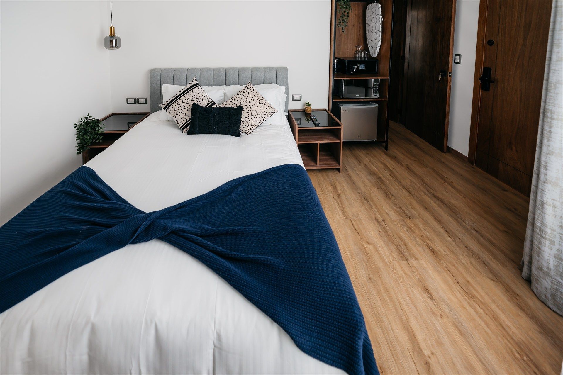 Una cama con una manta azul encima en una habitación de hotel.