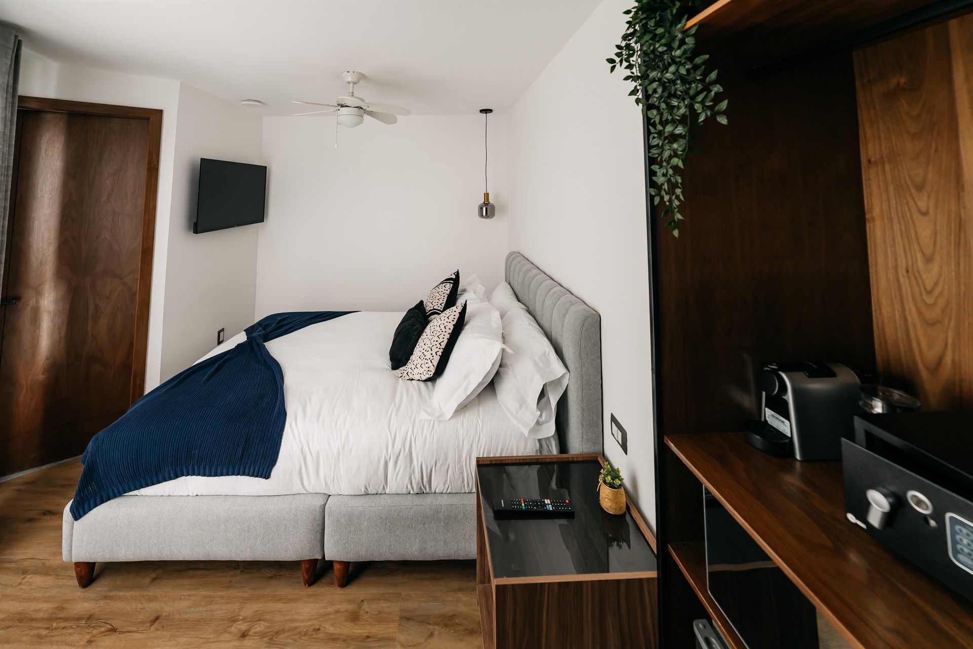 Un dormitorio con una cama grande y un televisor en la pared.