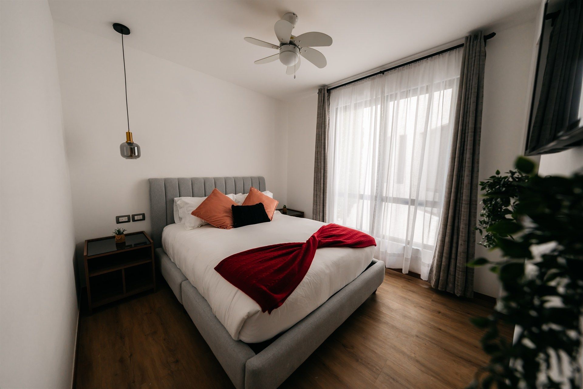 Un dormitorio con una cama y un ventilador de techo.
