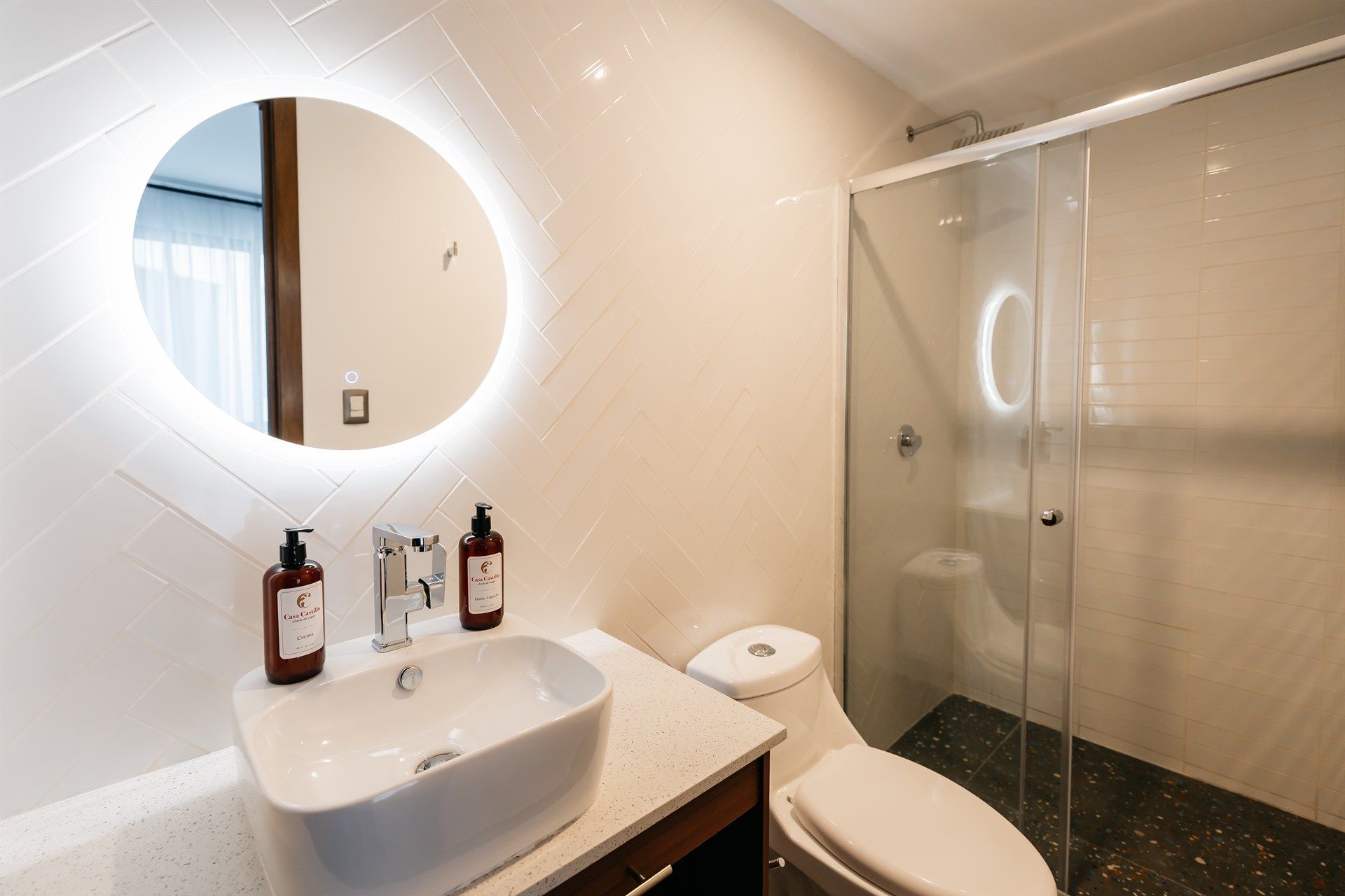 Un baño con lavabo, inodoro, ducha y espejo.