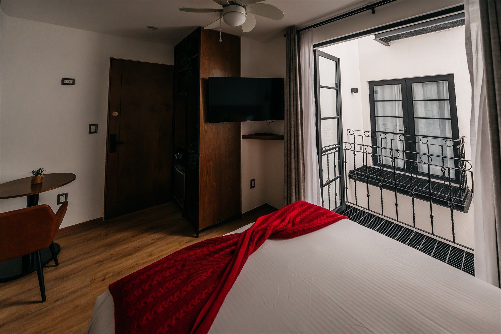 Una habitación de hotel con cama, televisión y balcón.