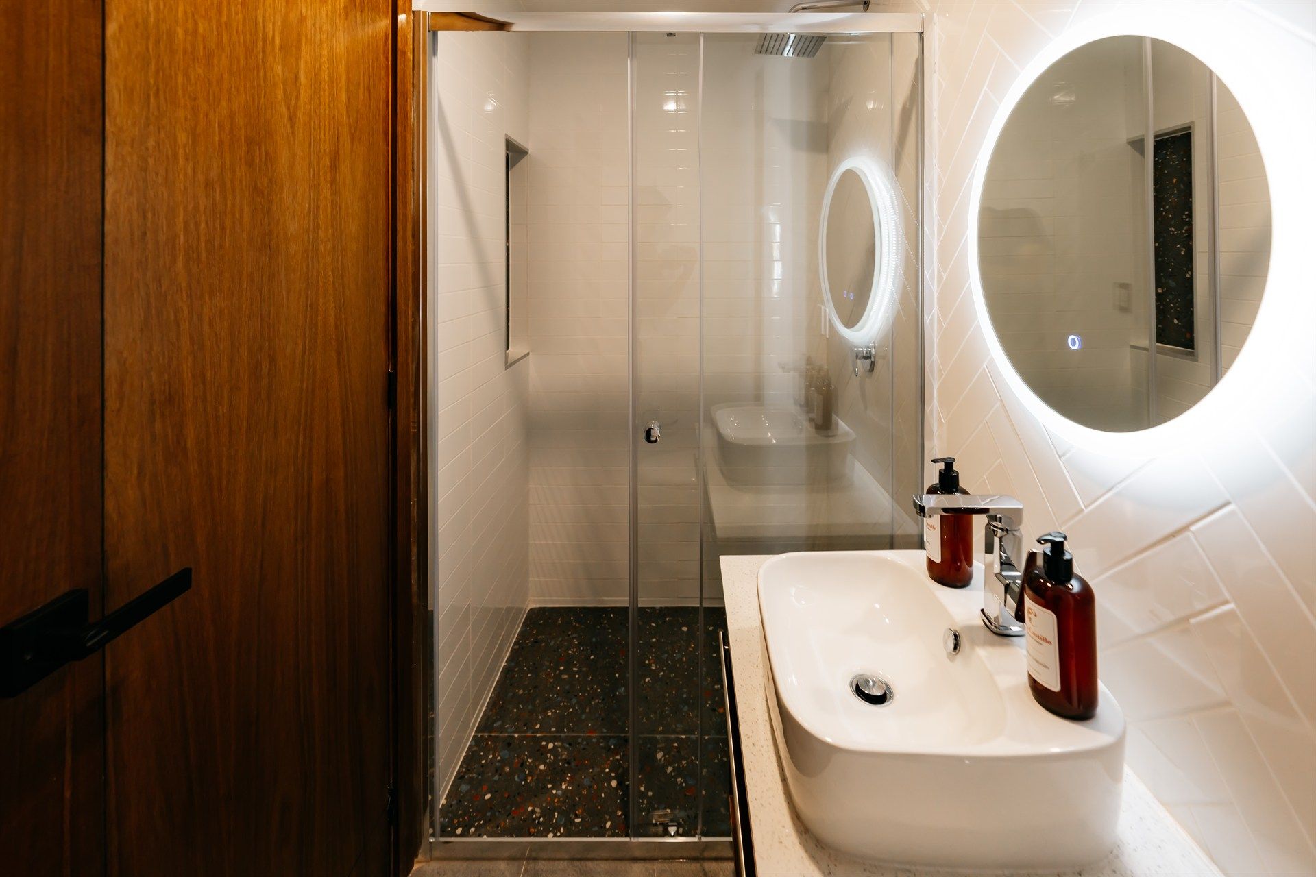 Un baño con lavabo, espejo y ducha.