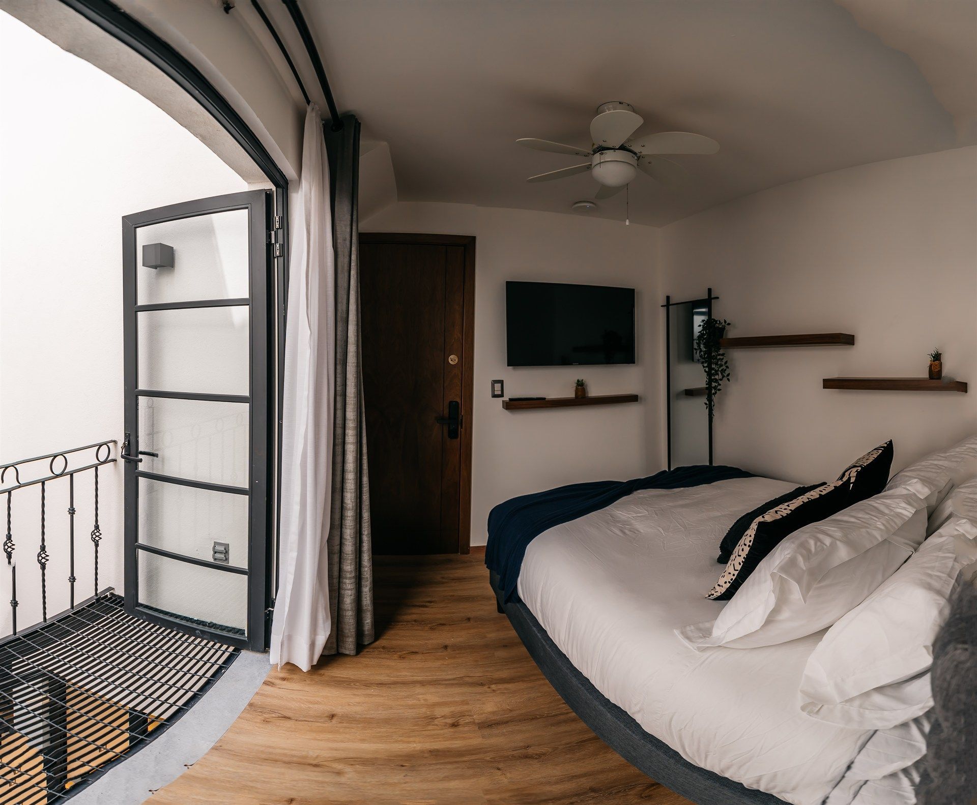 Un dormitorio con una cama grande y un televisor de pantalla plana.