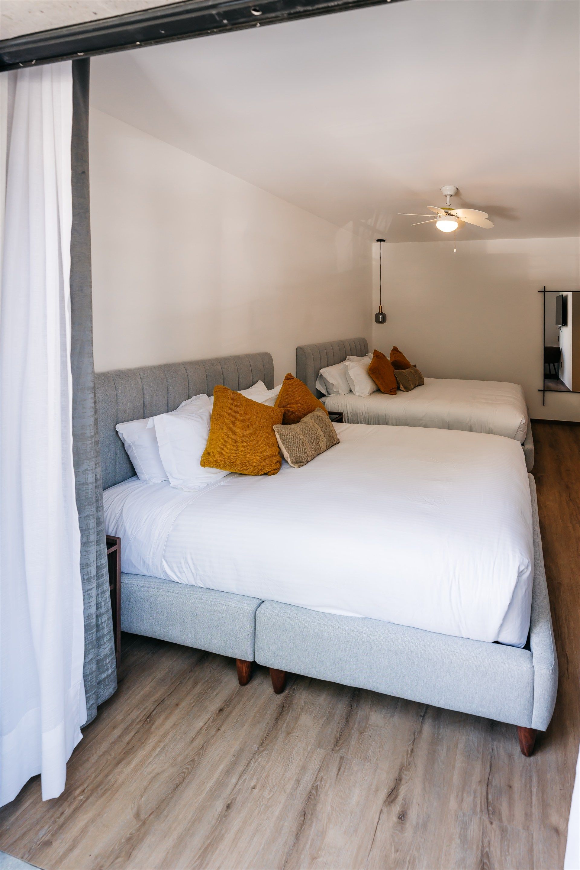 Una habitación de hotel con dos camas y un ventilador de techo.