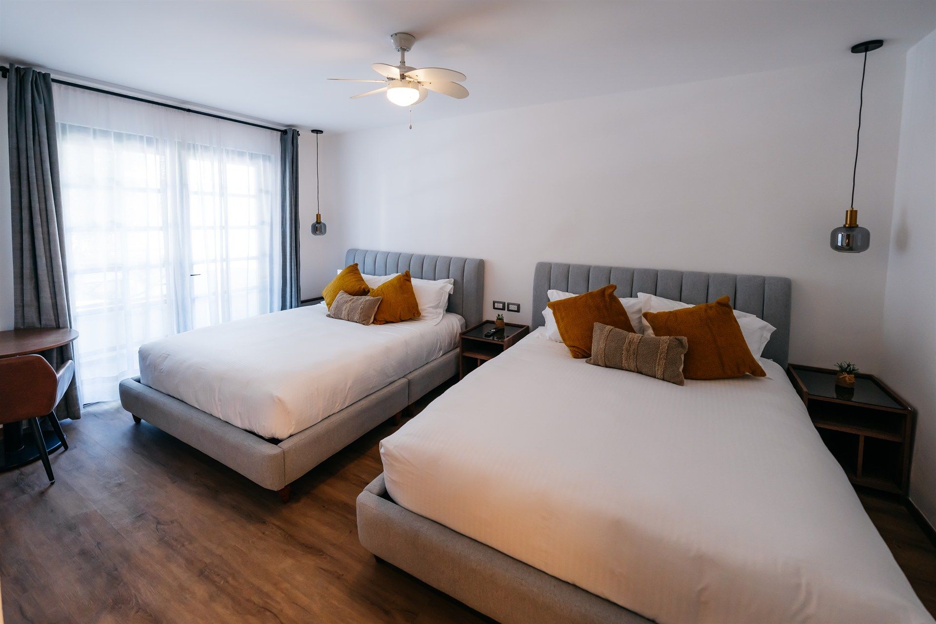 Una habitación de hotel con dos camas y un ventilador de techo.
