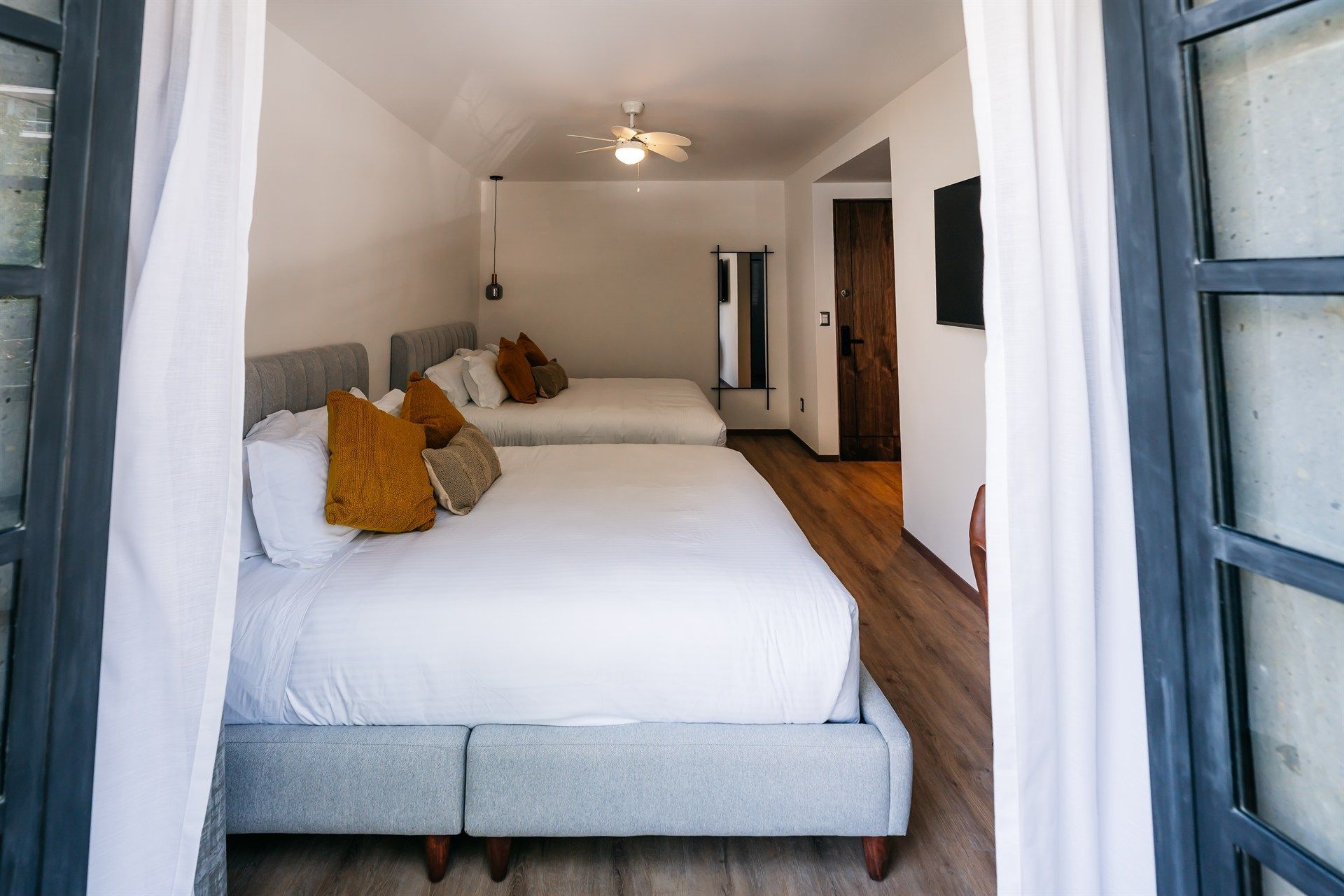 Una habitación de hotel con dos camas y un ventilador de techo.