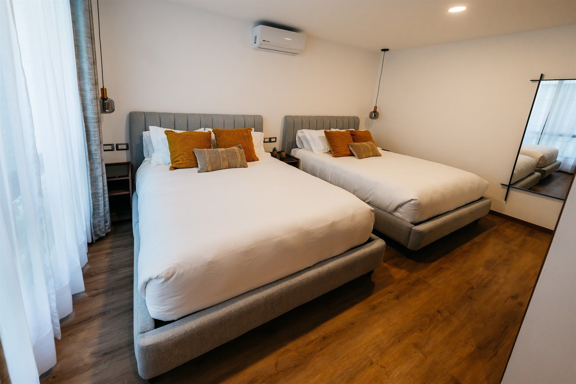 Una habitación de hotel con dos camas y un espejo.