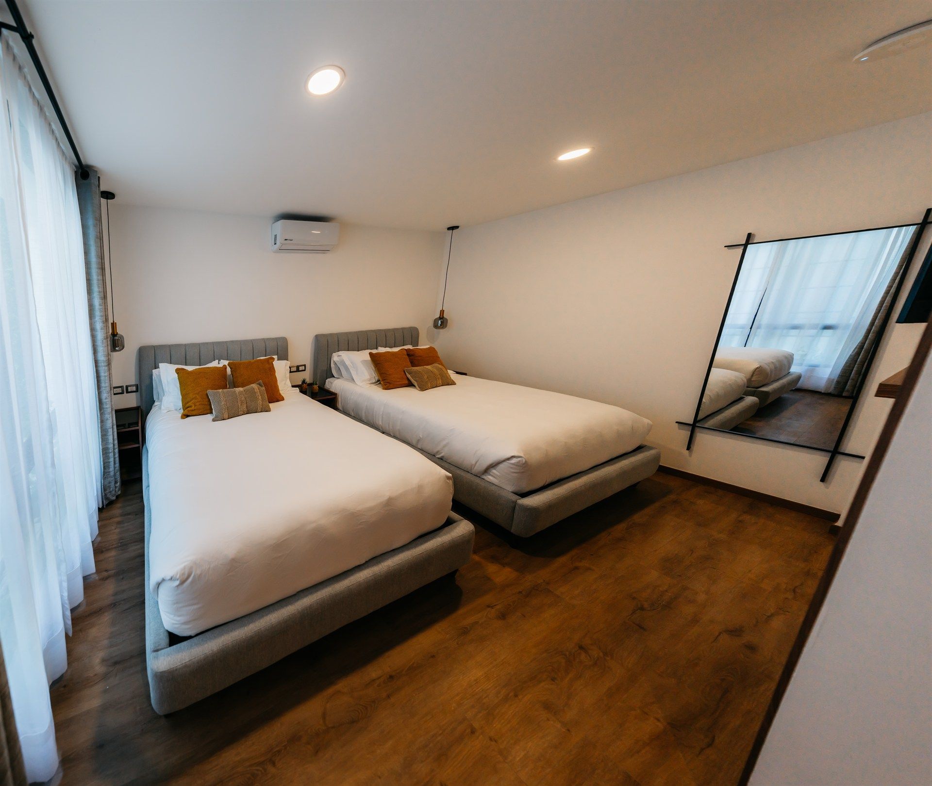 Una habitación de hotel con dos camas y un espejo.