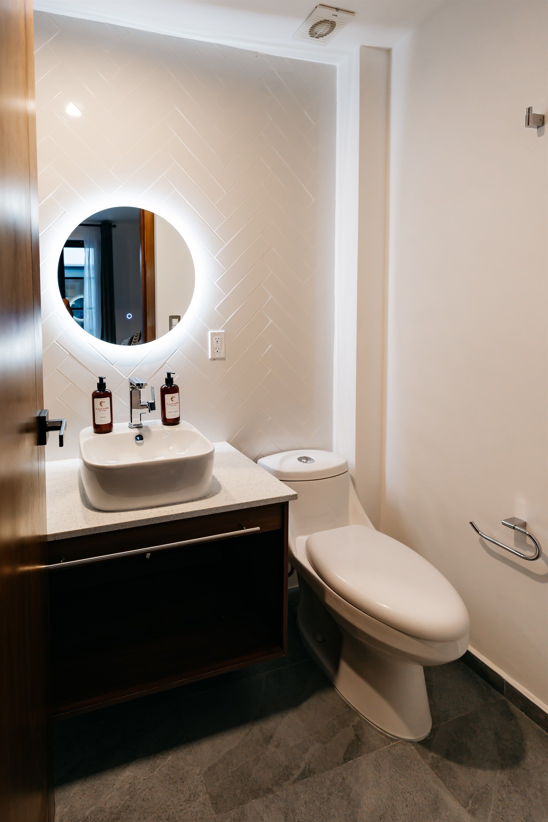 Un baño con inodoro, lavabo y espejo.