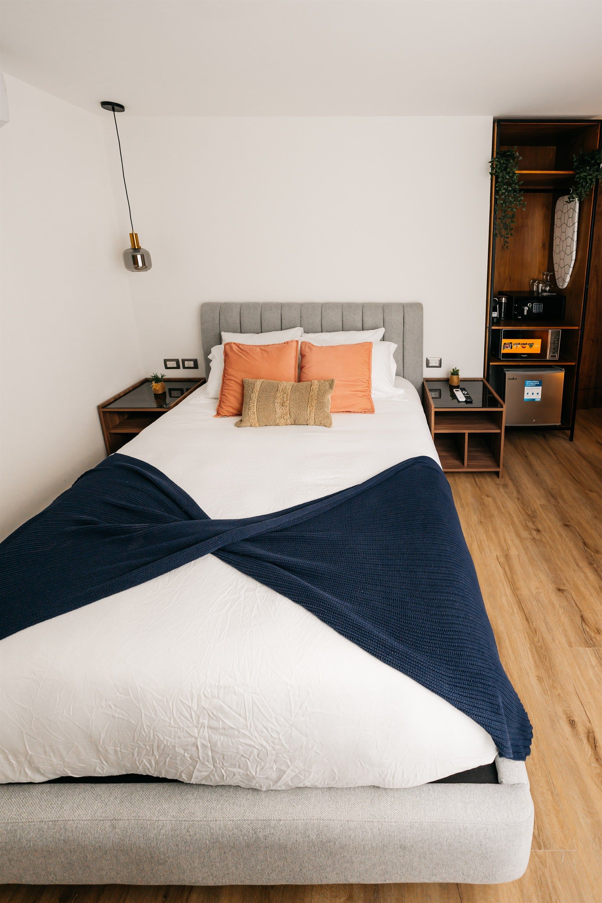 Una cama con una manta azul encima en una habitación de hotel.