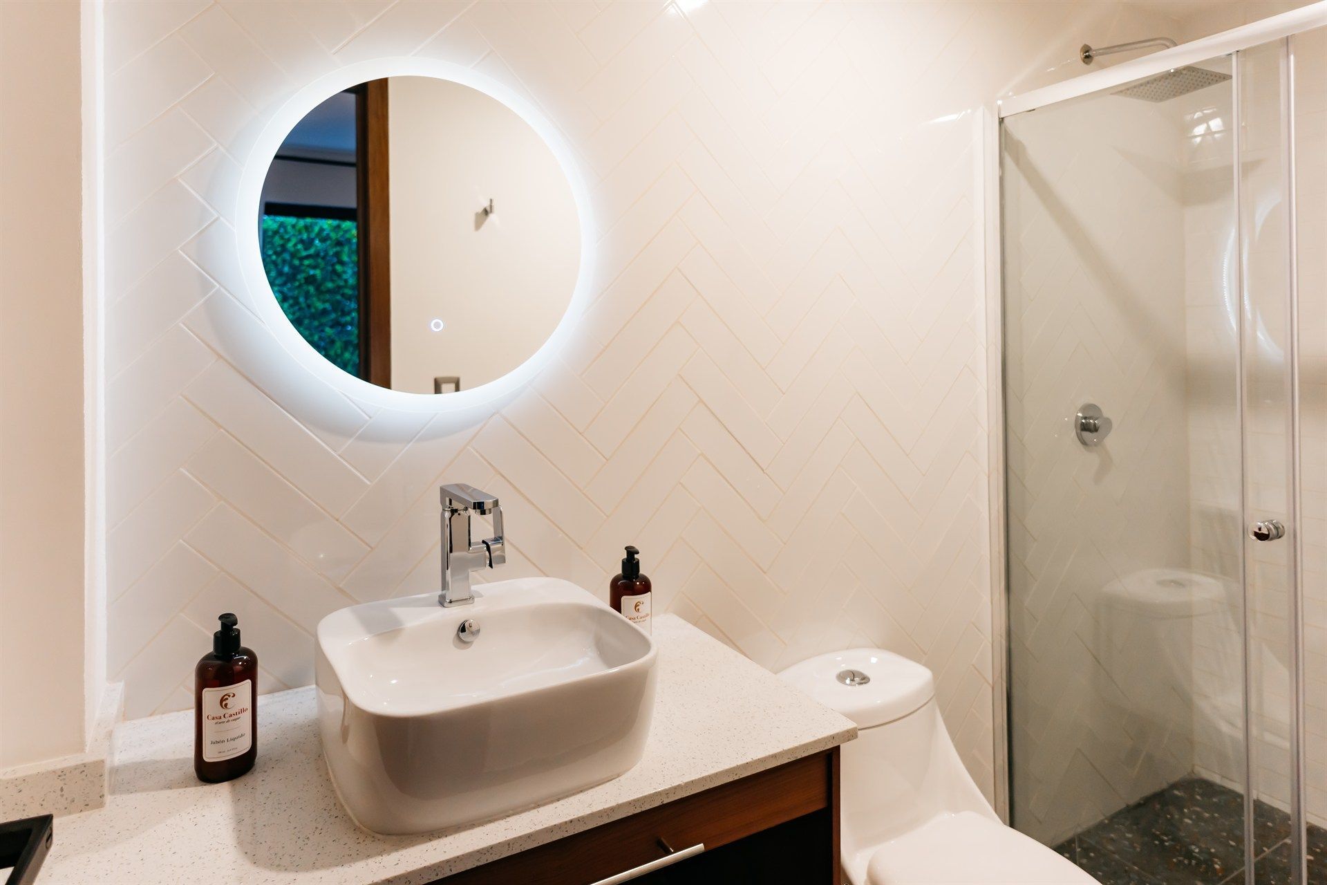 Un baño con lavabo, inodoro, ducha y espejo.