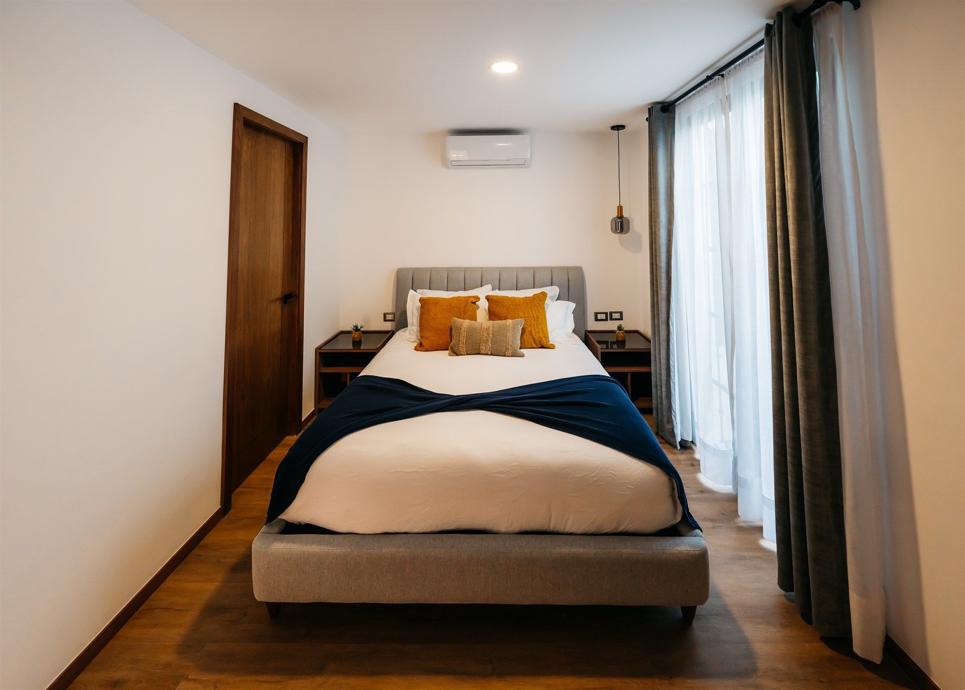 Un dormitorio con una cama grande y una puerta corrediza de vidrio.
