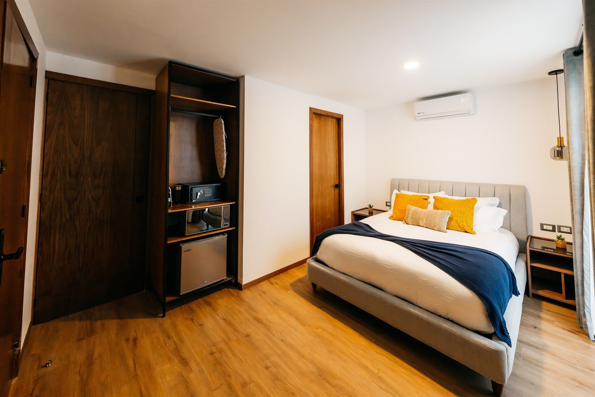Una habitación de hotel con una cama tamaño king y un refrigerador.