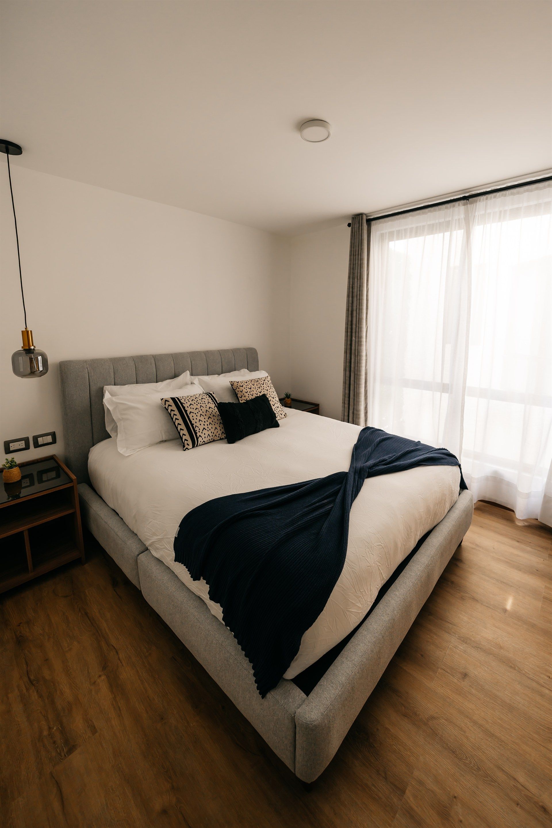 Un dormitorio con una cama grande y una ventana grande.