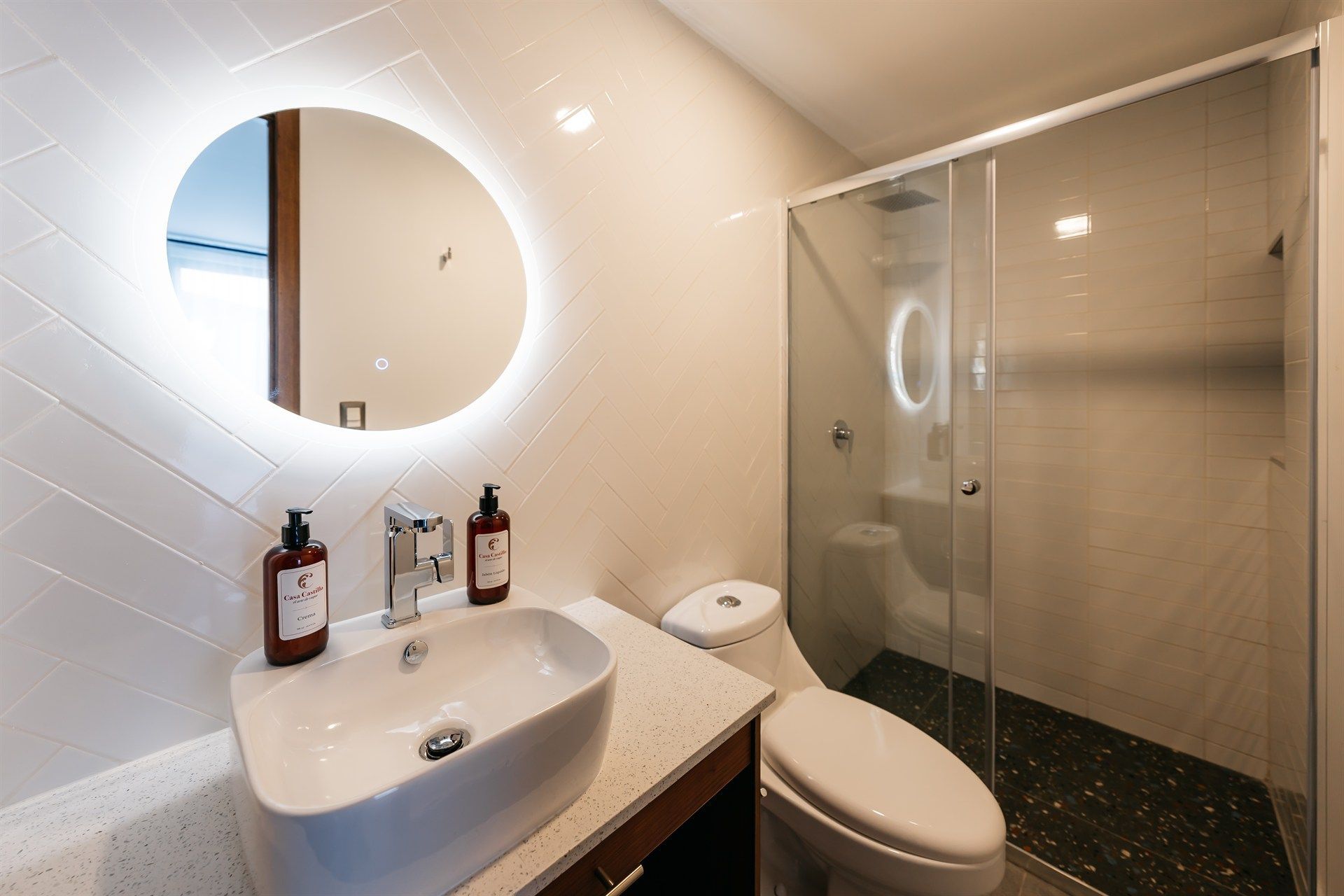 Un baño con lavabo, inodoro, ducha y espejo.
