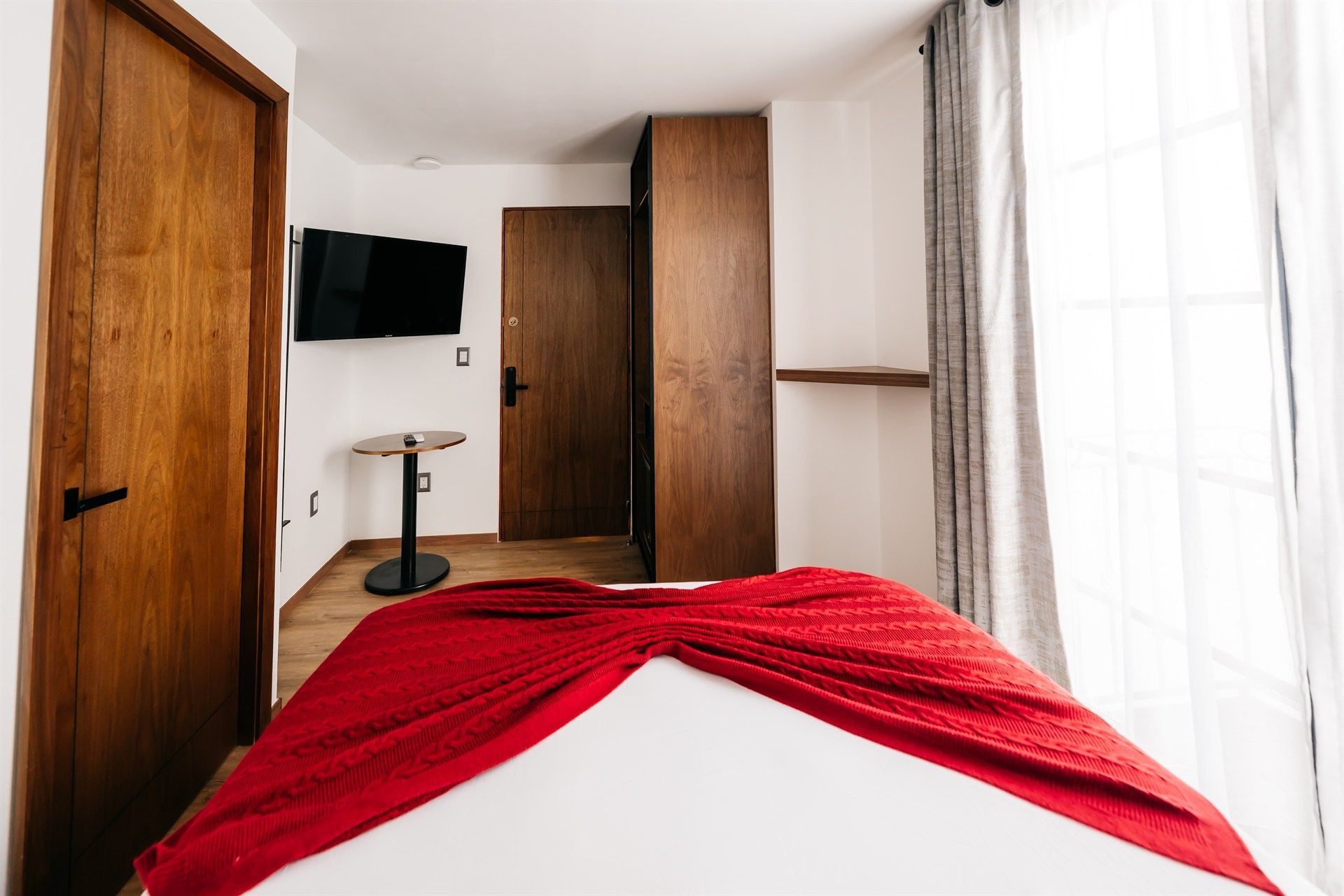 Una habitación de hotel con una cama, una mesa y una televisión.