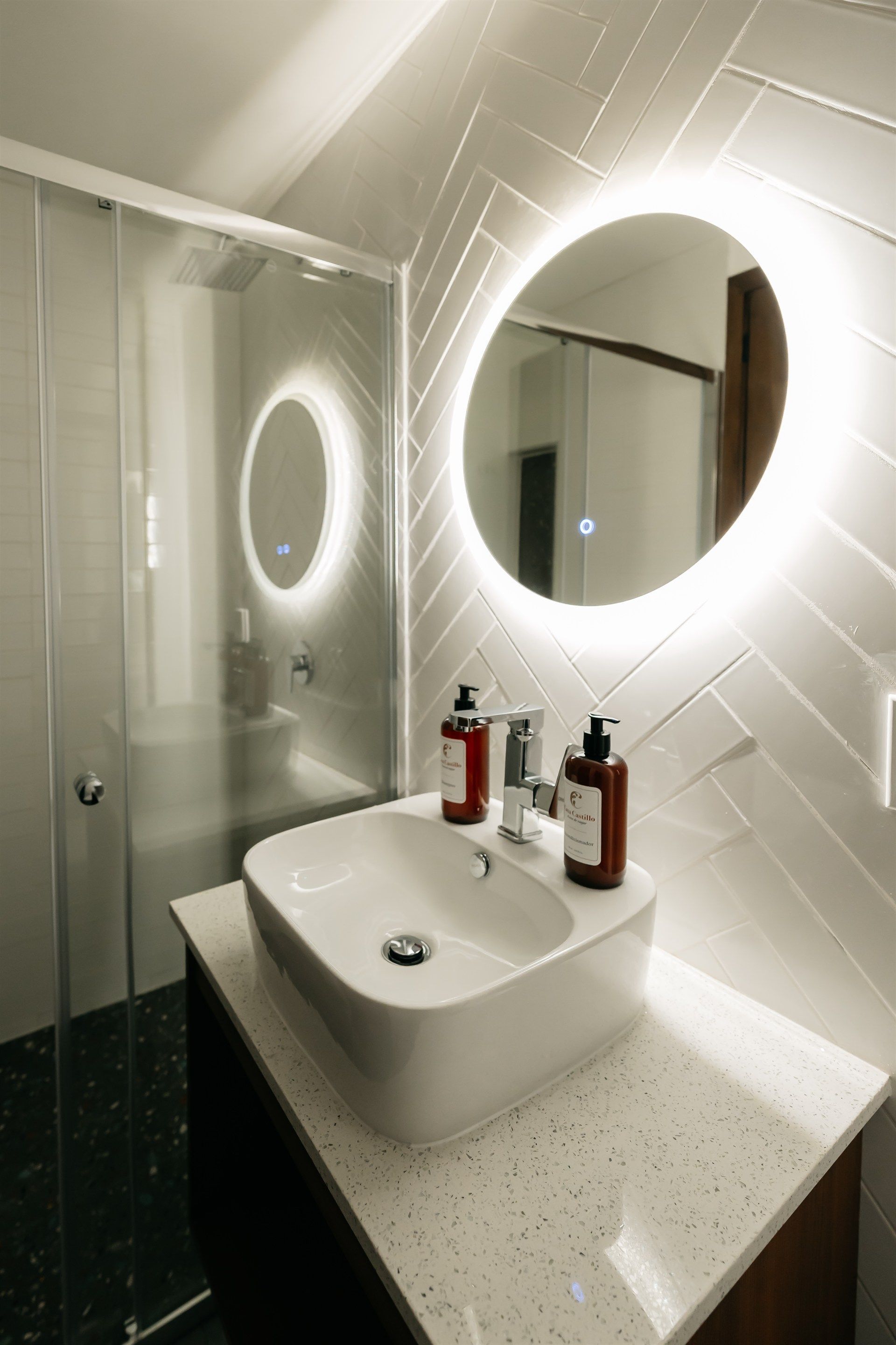 Un baño con lavabo, espejo y ducha.