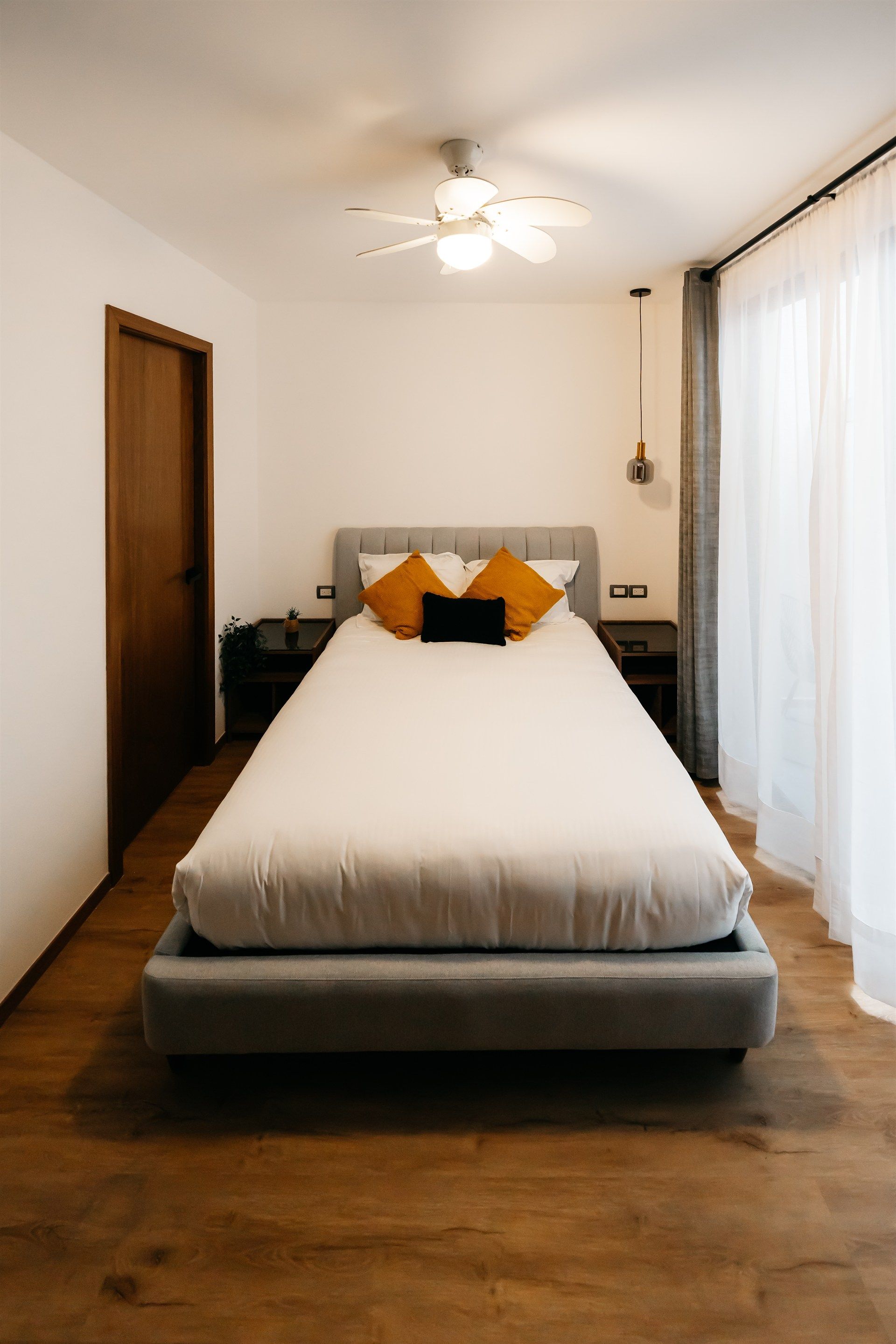 Un dormitorio con una cama y un ventilador de techo.